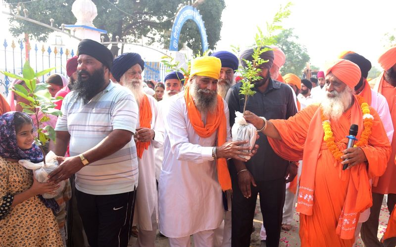 MP Balbir Singh Seechewal distributes plants to people in the Green Nagar Kirtan. Tribune photo: Malkiat Singh